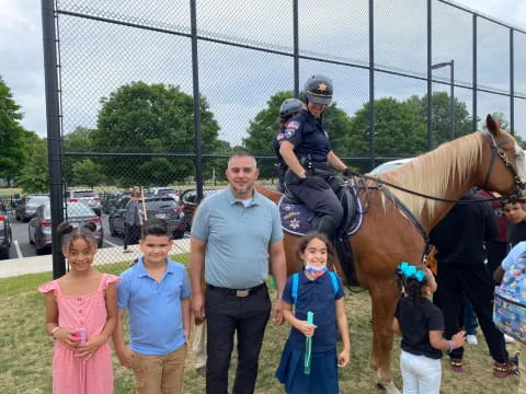 a police officer on a horse with a group of children