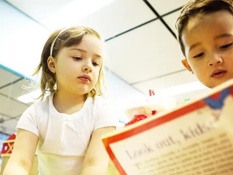 a boy and girl looking at a book