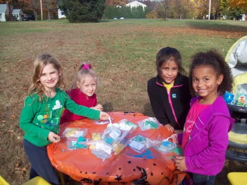 a group of girls holding a large colorful box