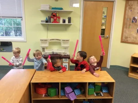 a group of kids sitting at a table with a toy sword