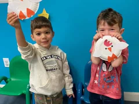 two boys holding up paper hearts