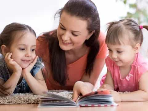 a person and two children looking at a tablet