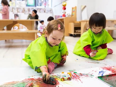 a couple of young girls playing on the floor