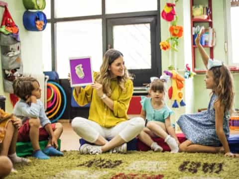 a woman and several children sitting on the floor