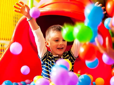 a boy in a ball pit