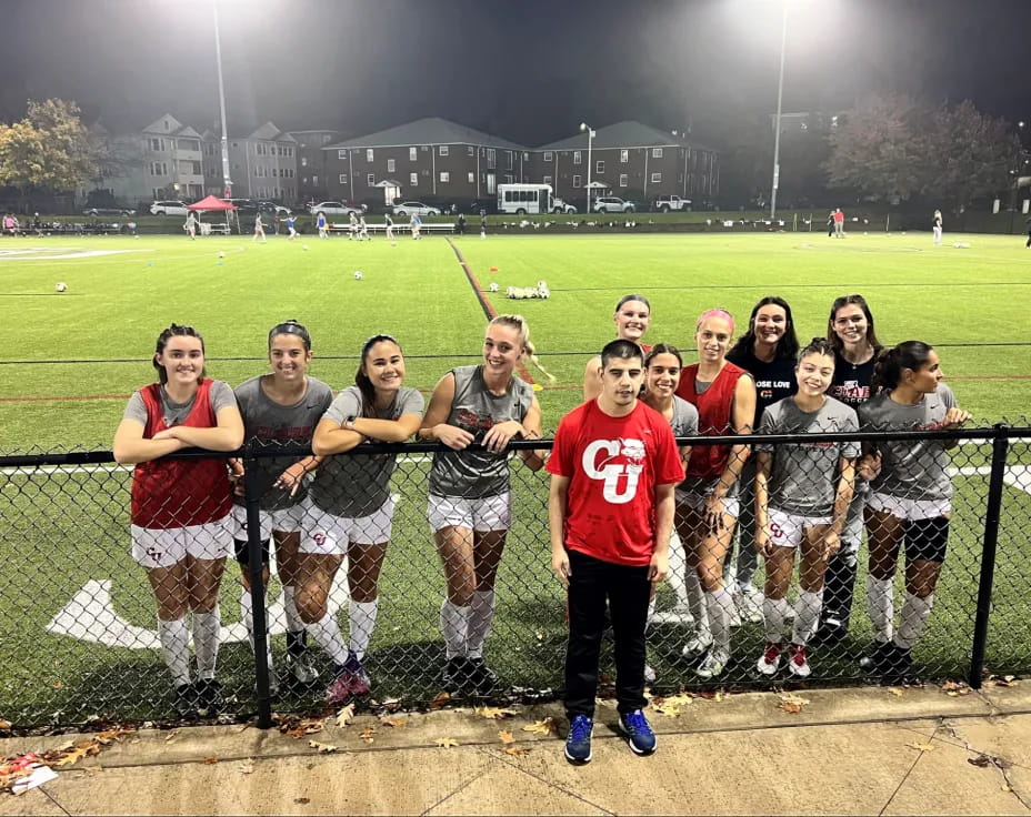 a group of people posing for a photo on a field