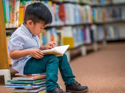 a young boy reading a book