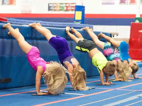 a group of girls doing a plank on a mat