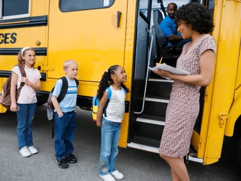 a group of people standing next to a school bus