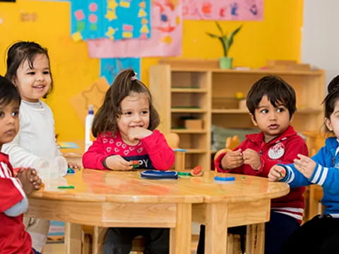 a group of children sitting around a table