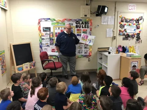 a person standing in front of a classroom of children