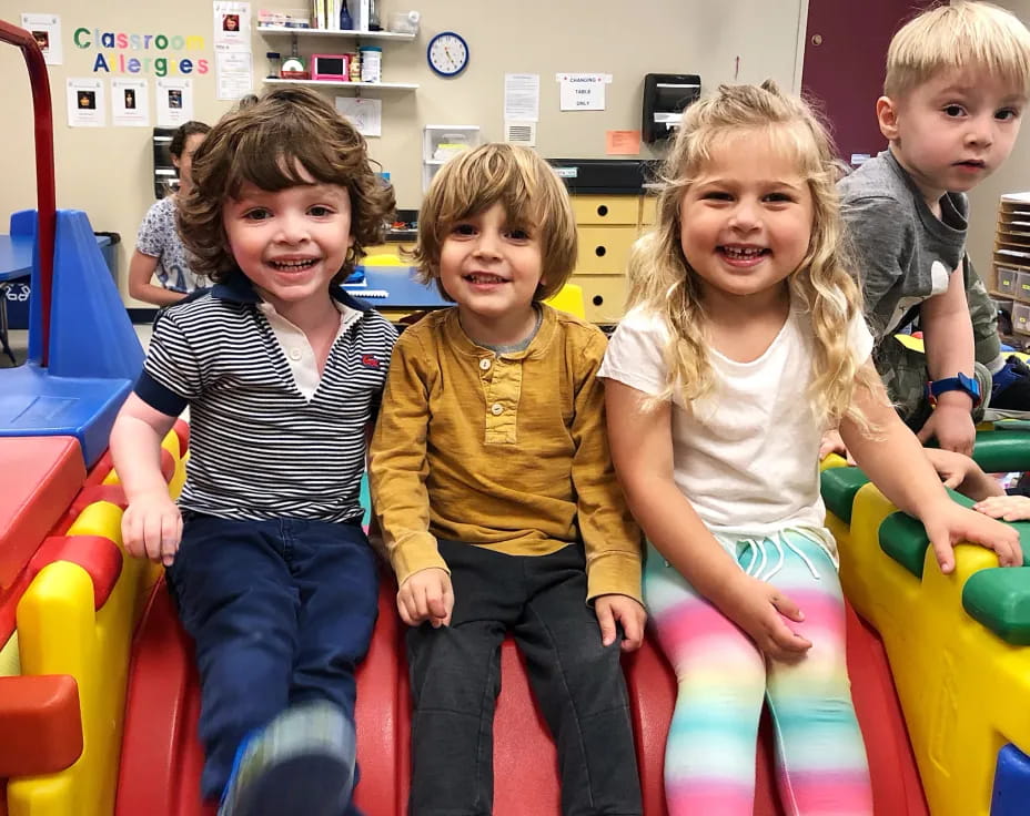 a group of children sitting on a colorful toy