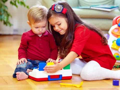 a person and a child playing with toys on the floor