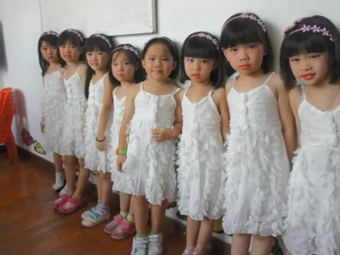 a group of girls in white dresses