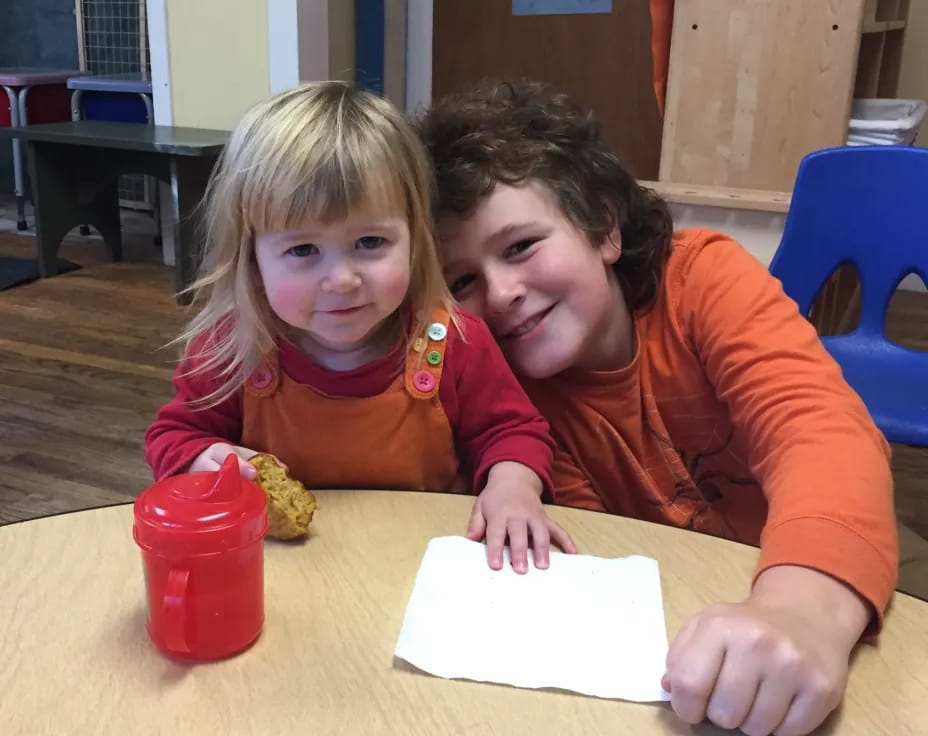 a person and a girl sitting at a table