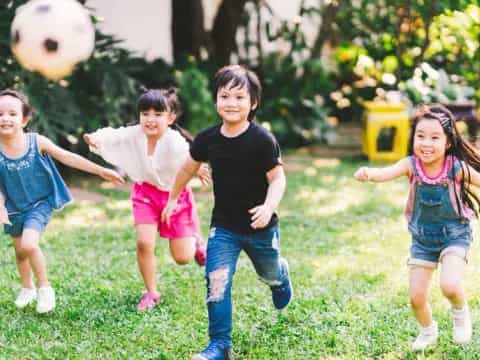 a group of children playing with a ball in a yard