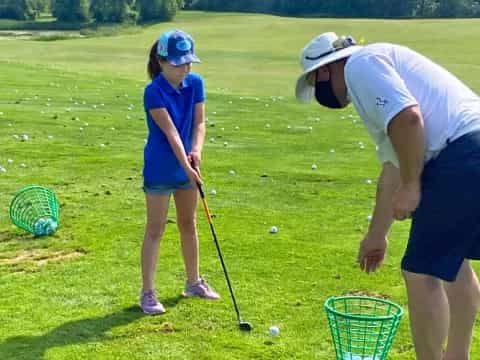 a person and a girl playing golf