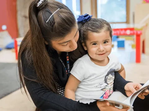 a person and a child looking at a book