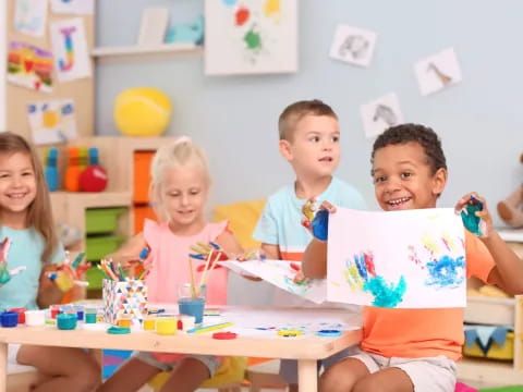 a group of children sitting at a table with toys