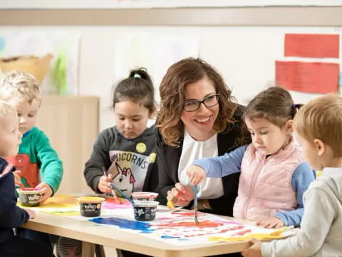 a person and several children sitting at a table