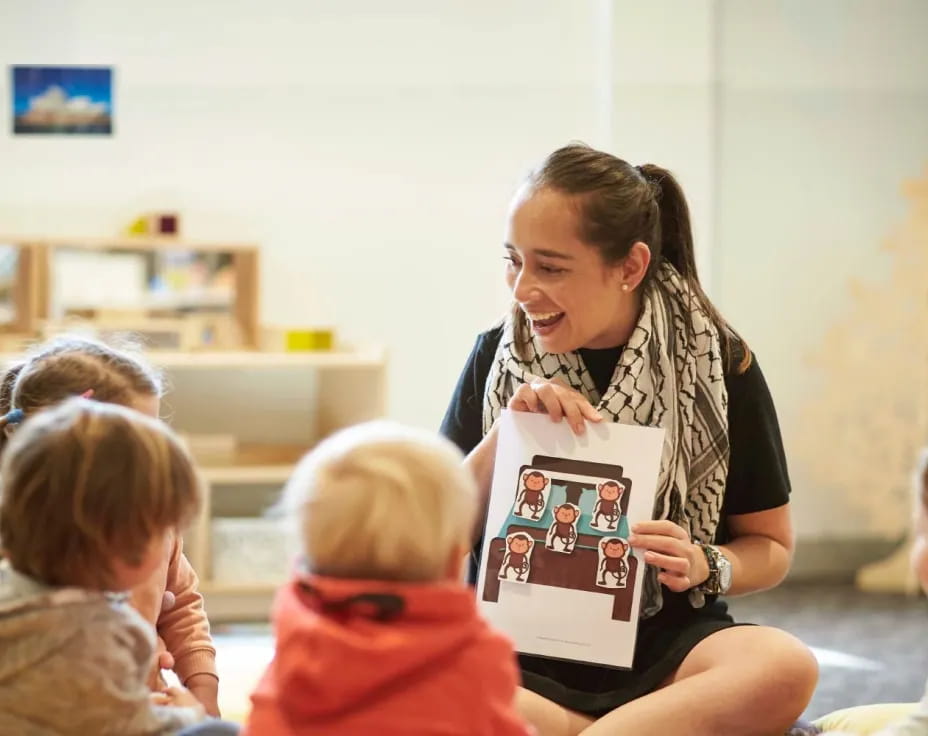 a person holding a book in front of a group of children