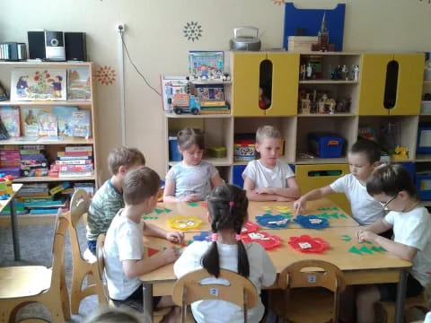 a group of children sitting around a table