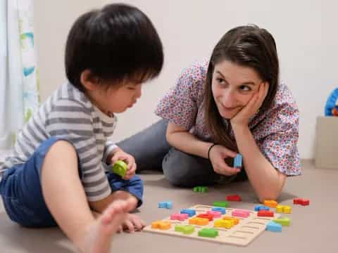 a person and a child playing with toys on the floor