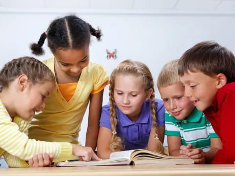 a group of children looking at a book