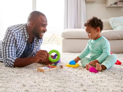 a person and a child playing with toys on the carpet