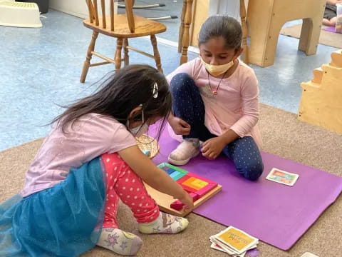 a young girl and a young girl playing on a mat