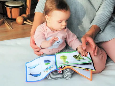 a person and a baby playing with a puzzle