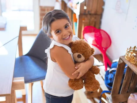 a girl holding a teddy bear