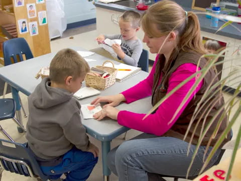 a woman and two boys sitting at a table