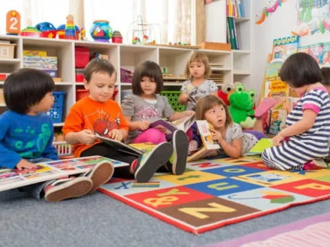 a group of children sitting on the floor playing a game