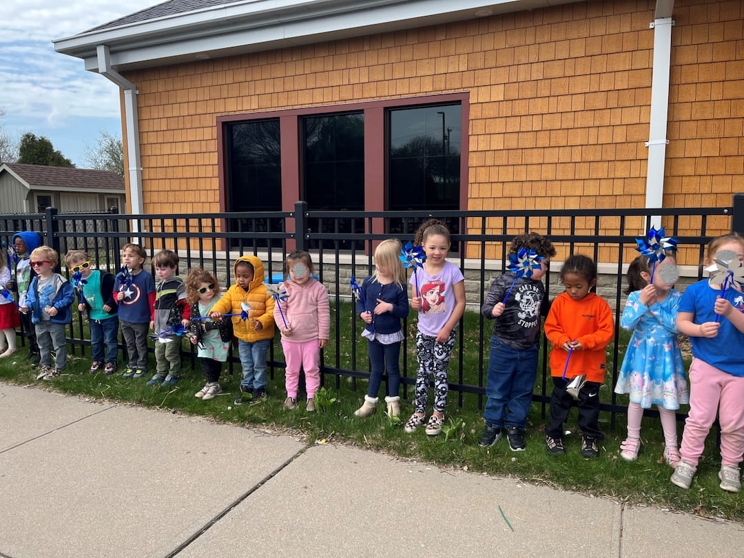 a group of children posing for a photo in front of a building