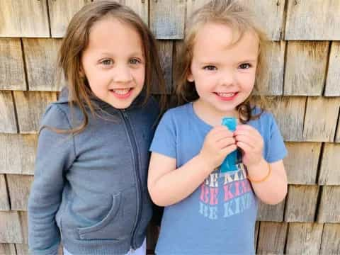 two girls smiling and holding a blue object