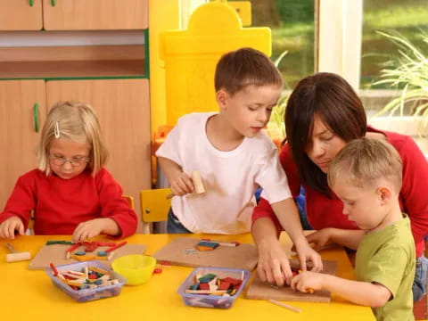 a group of children sitting at a table playing with toys