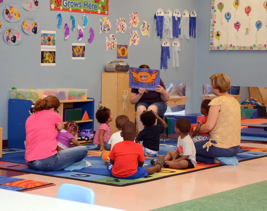 a group of children sitting on the floor in a classroom