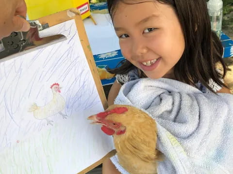a girl holding a chicken