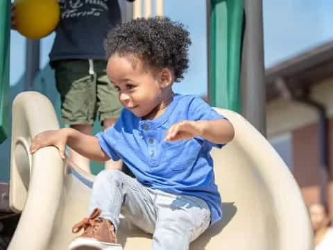 a young boy sitting on a slide