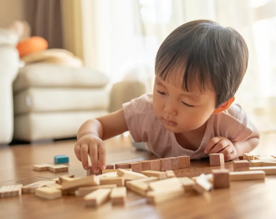 a baby playing with wooden blocks