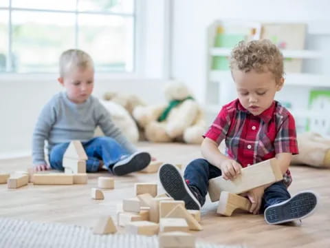 a couple of boys playing with building blocks