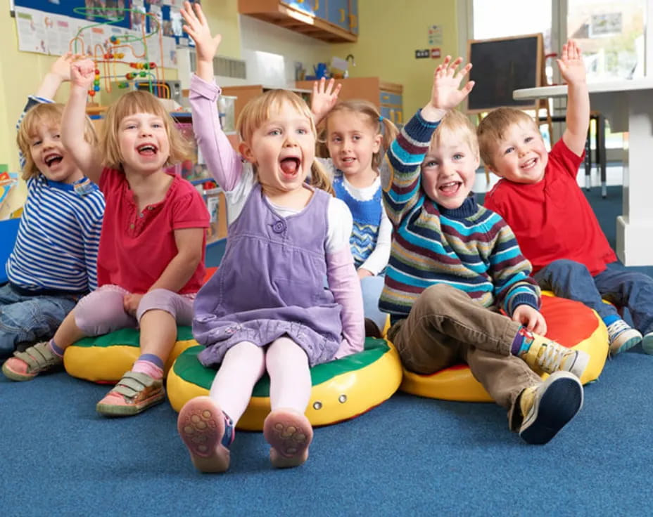 a group of children sitting on a green and yellow toy