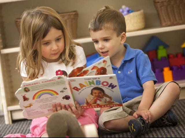 a couple of children reading a book