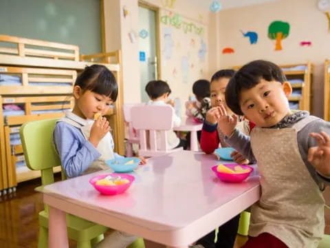 a group of children eating at a table