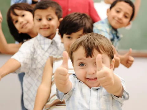 a group of children raising their hands