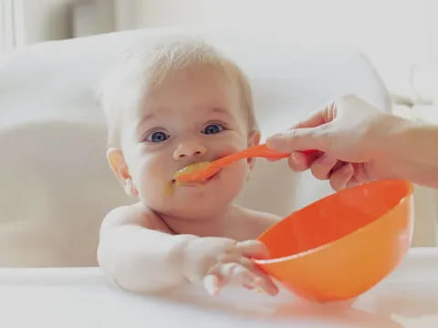 a baby in a bathtub with a toothbrush in its mouth