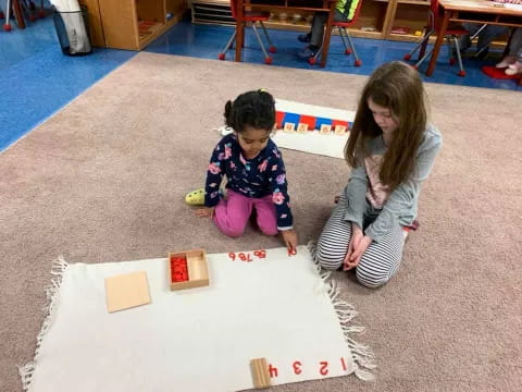 a person and a child playing with toys on the floor