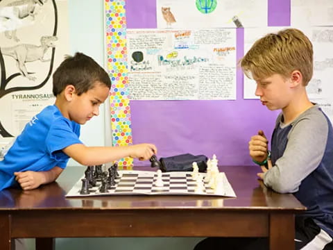 a couple of boys playing chess