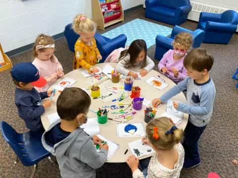 a group of children sitting around a table